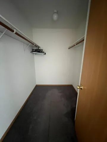 an empty room with a wooden floor and toilet