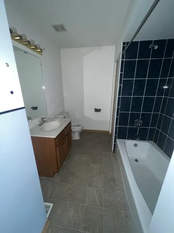 a bathroom with a tub sink and mirror