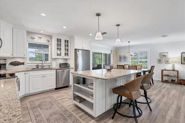 a kitchen with appliances cabinets and chairs
