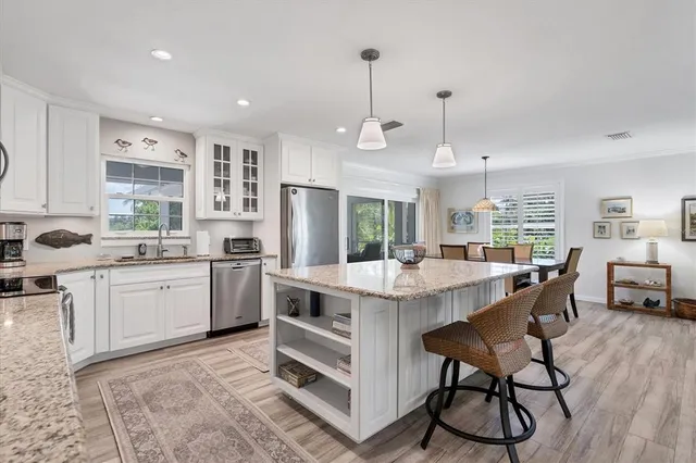 a kitchen with appliances cabinets and chairs