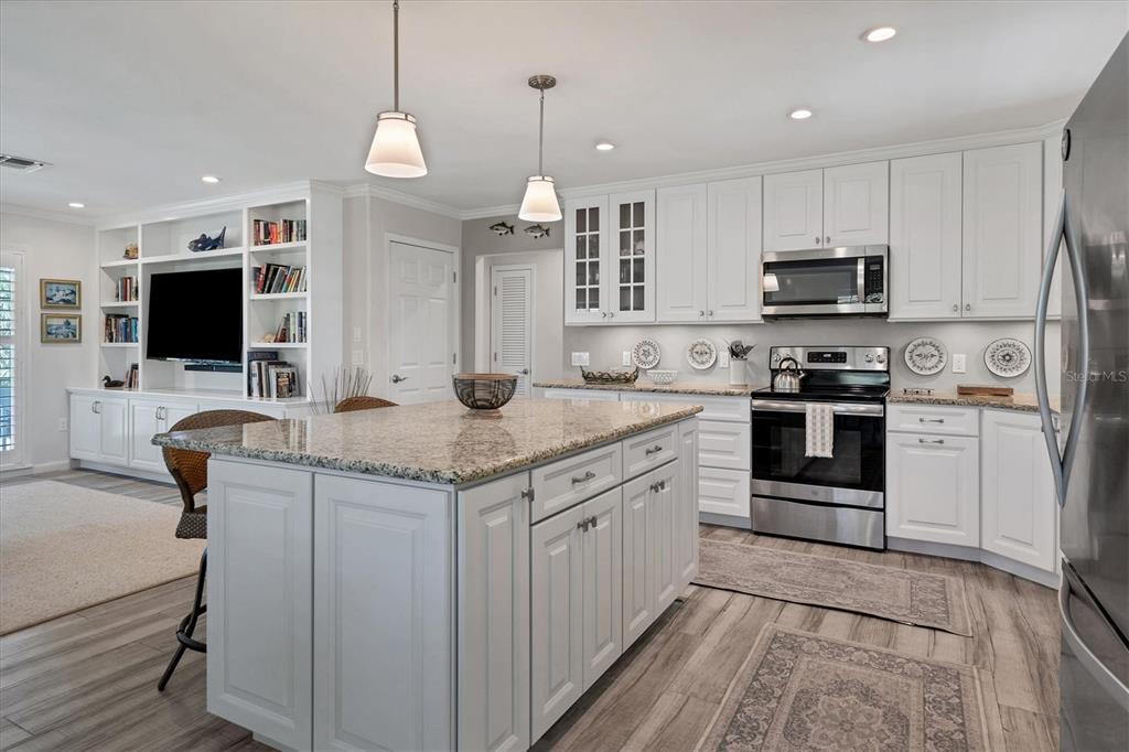4010 40th Street West Boca Grande, FL 33921 - Photo 15 of 48 a kitchen with kitchen island granite countertop a stove top oven a sink dishwasher a dining table and chairs with wooden floor