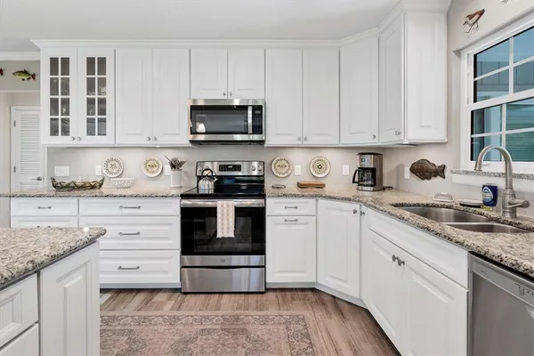 a kitchen with granite countertop white cabinets and white appliances