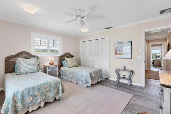 a bedroom with two beds and wooden floor