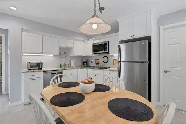 a kitchen with stainless steel appliances granite countertop a sink a refrigerator and a stove
