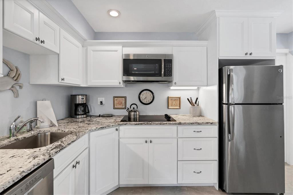 4010 40th Street West Boca Grande, FL 33921 - Photo 35 of 48 a kitchen with granite countertop a sink and a refrigerator