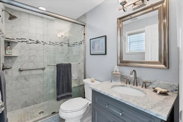 a bathroom with a granite countertop sink toilet and shower