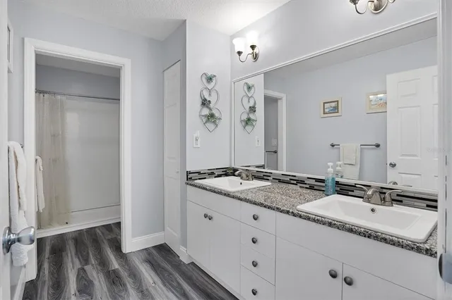 a bathroom with a granite countertop sink and a mirror