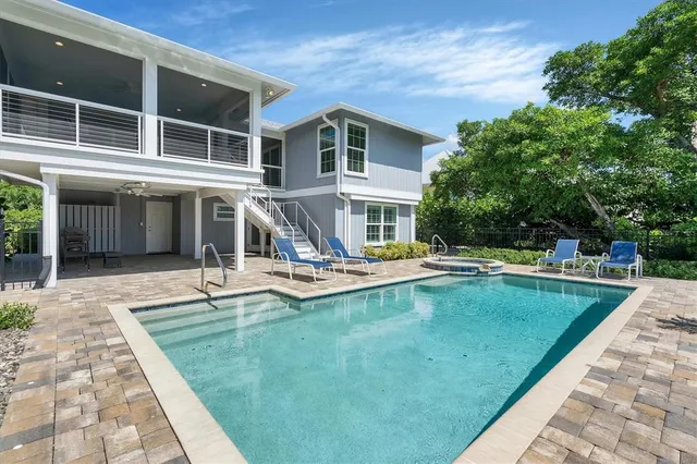 a view of a house with swimming pool and sitting area