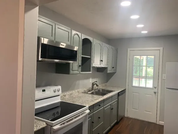 a kitchen with stainless steel appliances granite countertop a sink and a stove