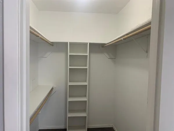 a view of walk in closet with empty racks