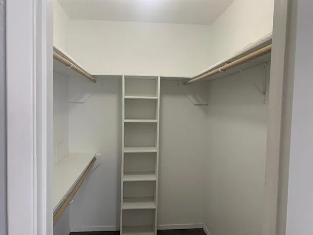 a view of walk in closet with empty racks