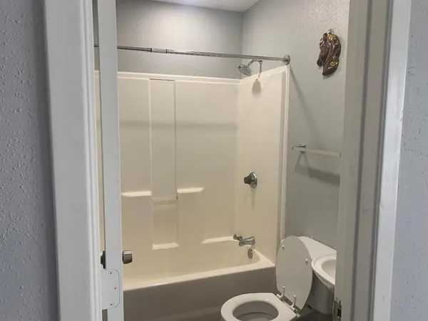 a bathroom with a shower a toilet and a sink