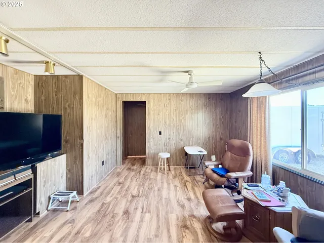 a living room with furniture a flat screen tv and a window