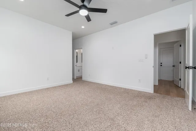 an empty room with a ceiling fan and a window