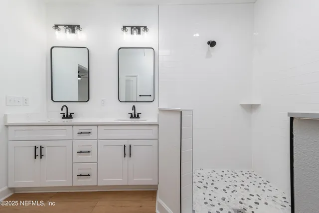 a bathroom with a double vanity sink mirror and
