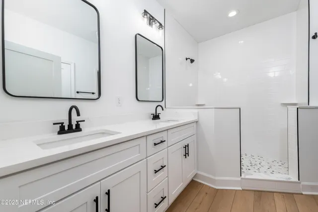 a bathroom with double vanity sink and a mirror