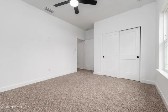 an empty room with chandelier fan