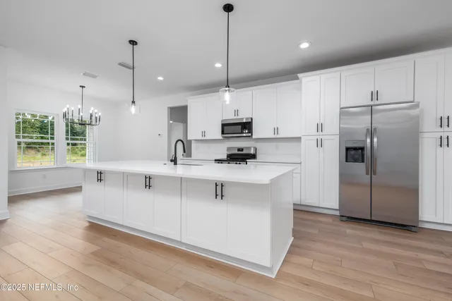 a kitchen with kitchen island white cabinets and refrigerator