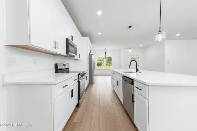 a kitchen with stainless steel appliances sink stove and cabinets