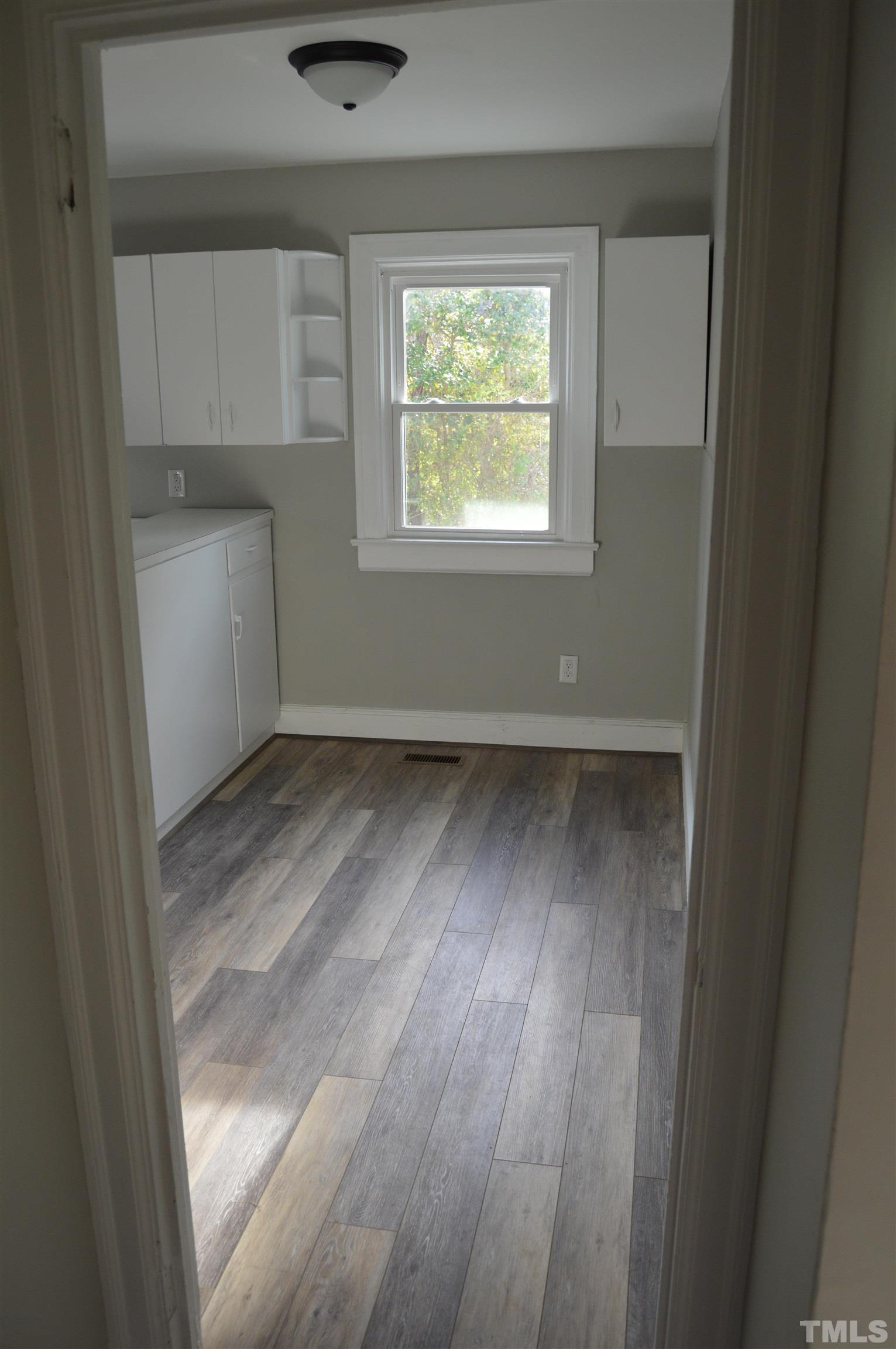 2123 Carthage Street Sanford, NC 27330 - Photo 16 of 18 an empty room with wooden floor and windows