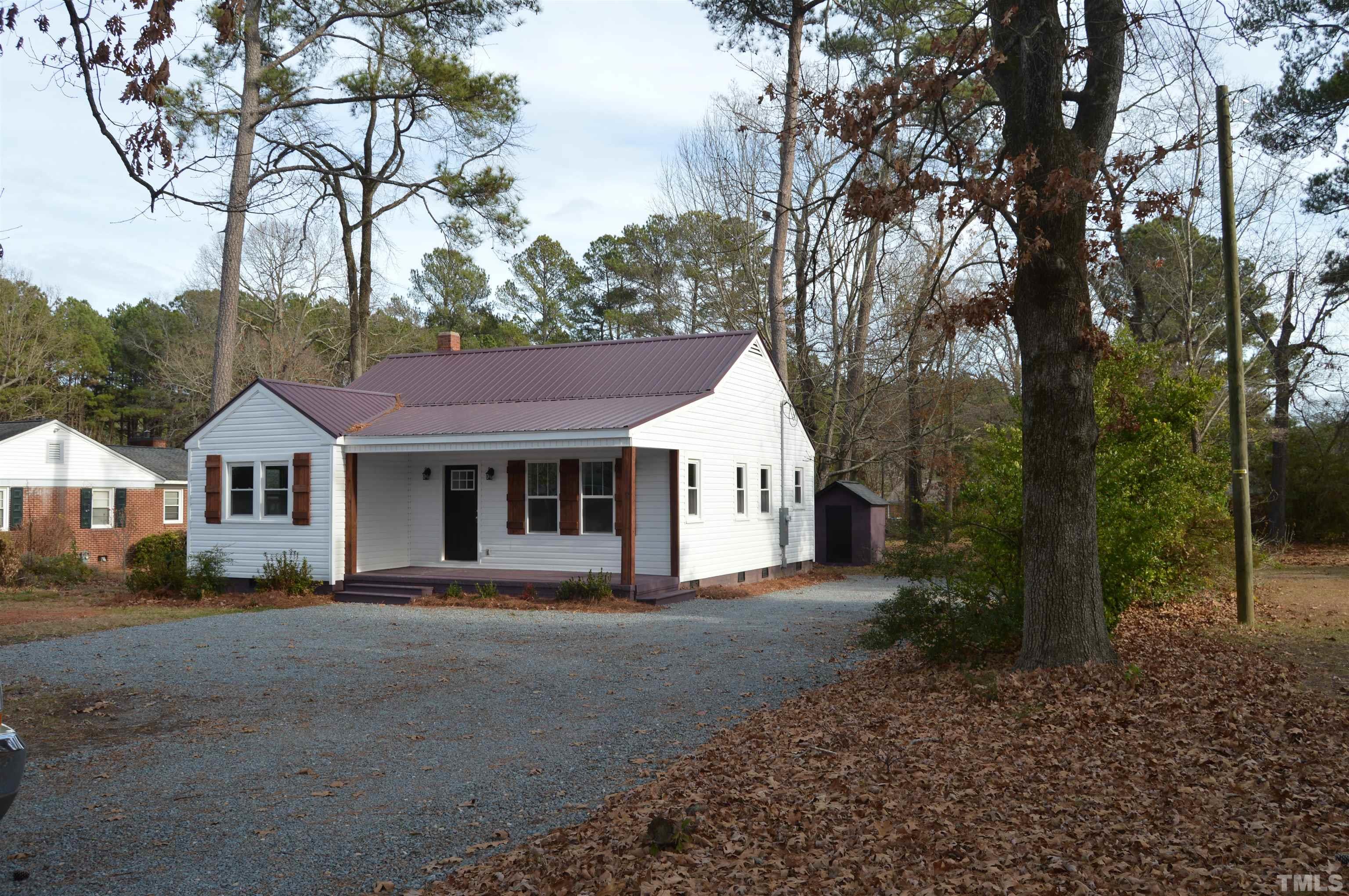 2123 Carthage Street Sanford, NC 27330 - Photo 3 of 18 a front view of a house with a yard and trees
