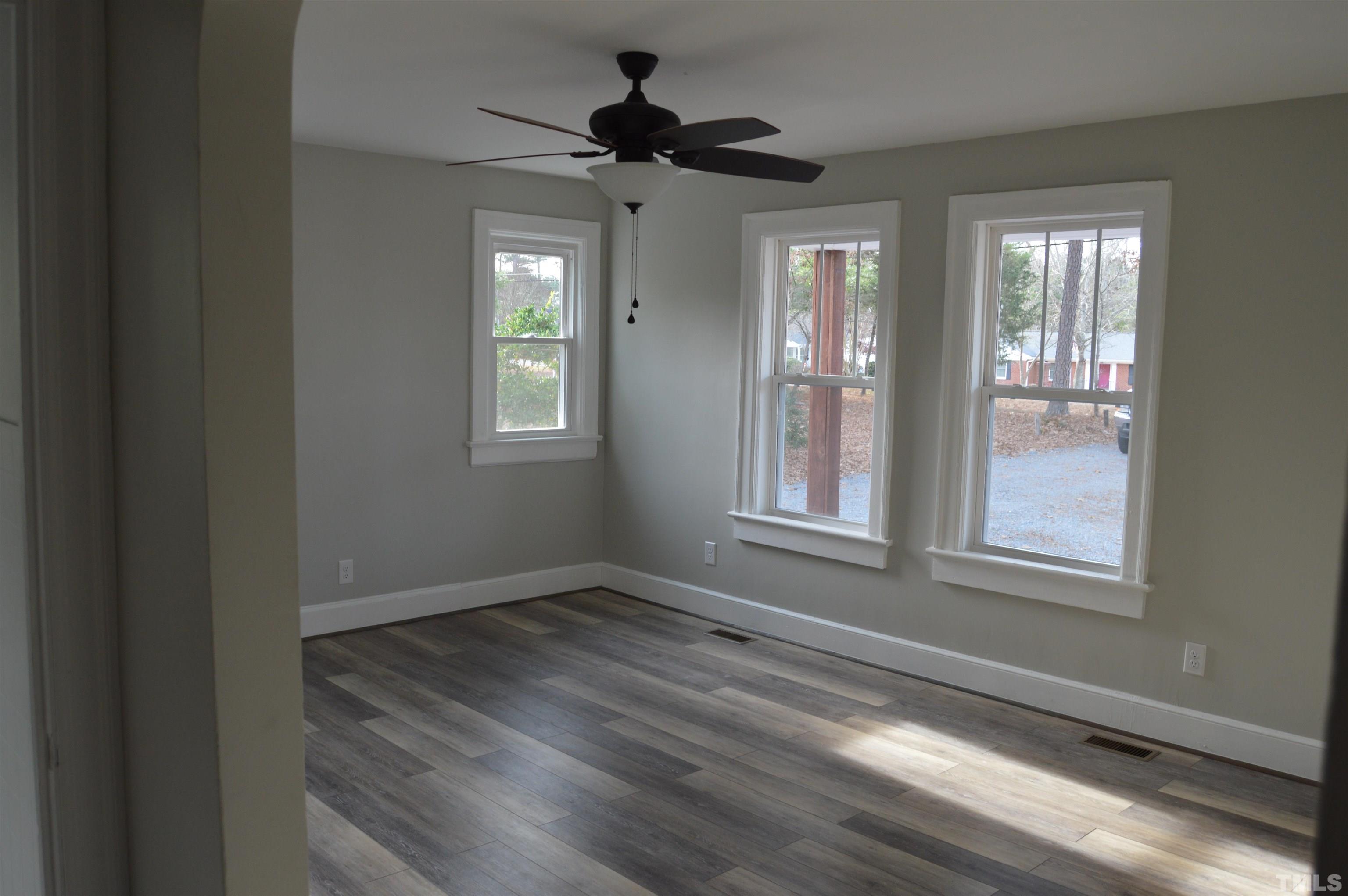 2123 Carthage Street Sanford, NC 27330 - Photo 9 of 18 a view of an empty room with a window and wooden floor
