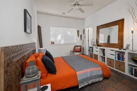 a bedroom with a bed a window and a mirror