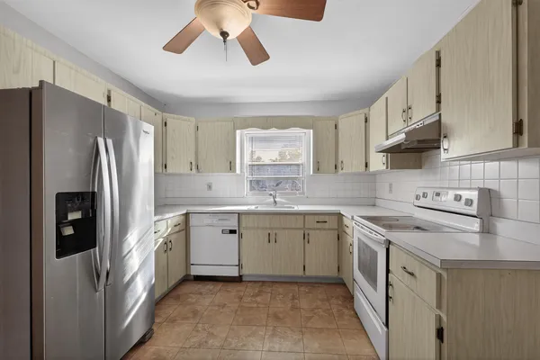 a kitchen with a white cabinets and refrigerator