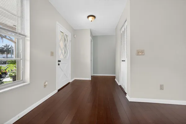 a view of a hallway with wooden floor and a window