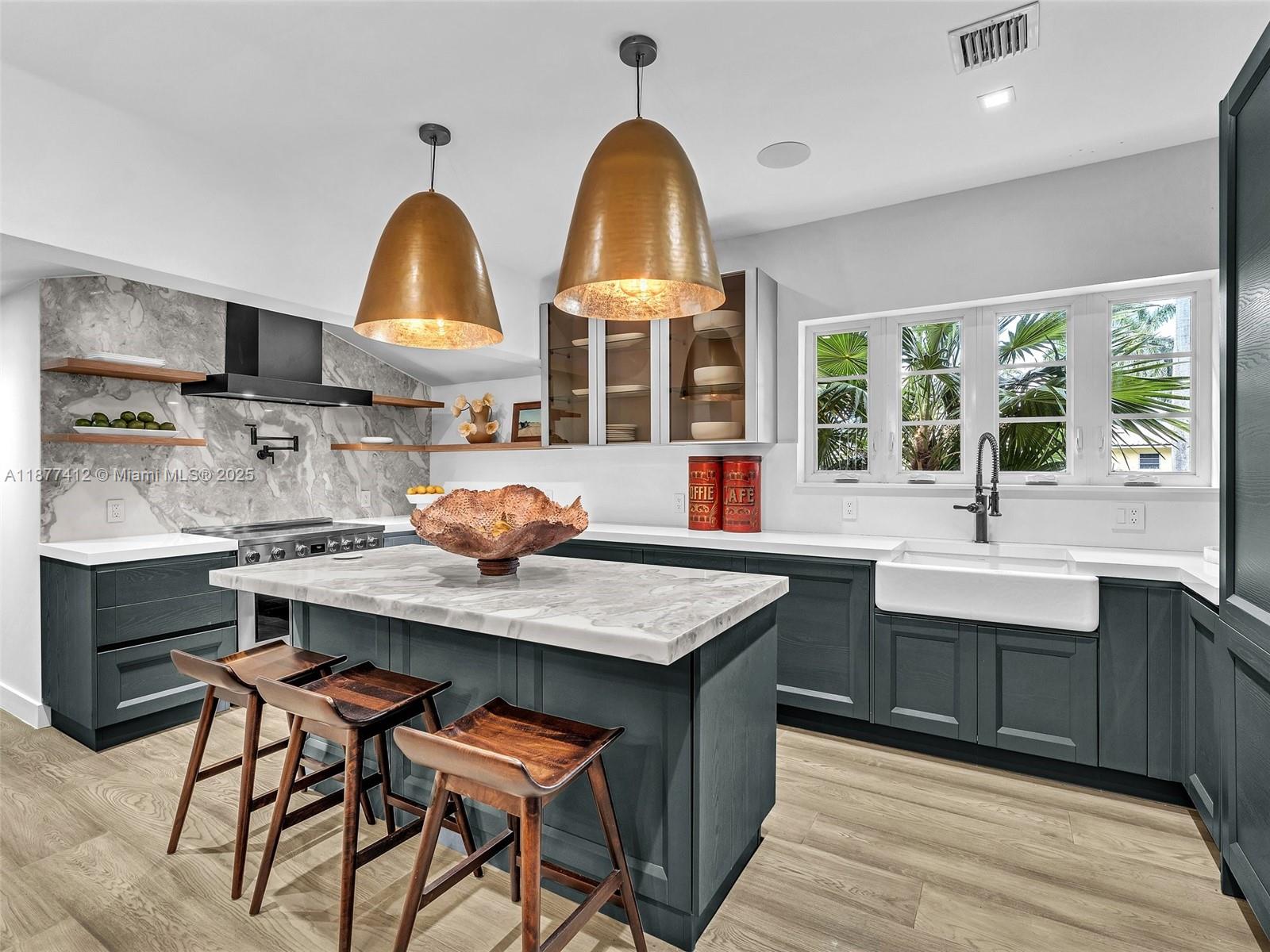 856 Tyler Street Hollywood, FL 33019 - Photo 16 of 52 a kitchen with stainless steel appliances a sink a stove and a wooden floors