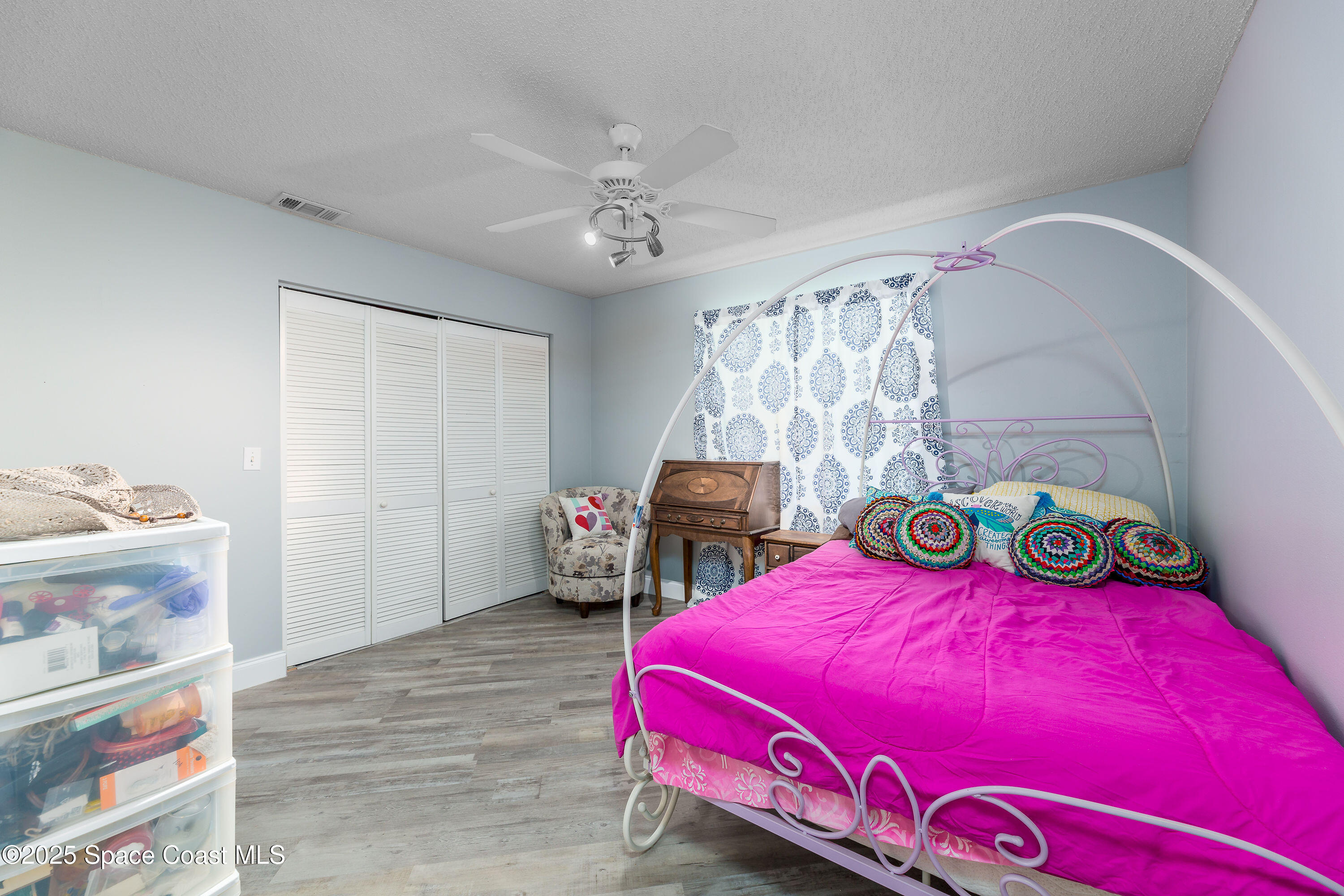 1135 Audubon Road Merritt Island, FL 32953 - Photo 22 of 52 a bedroom with a bed a dresser and a chandelier