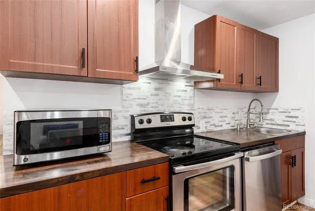 a kitchen with stainless steel appliances granite countertop a sink stove and microwave