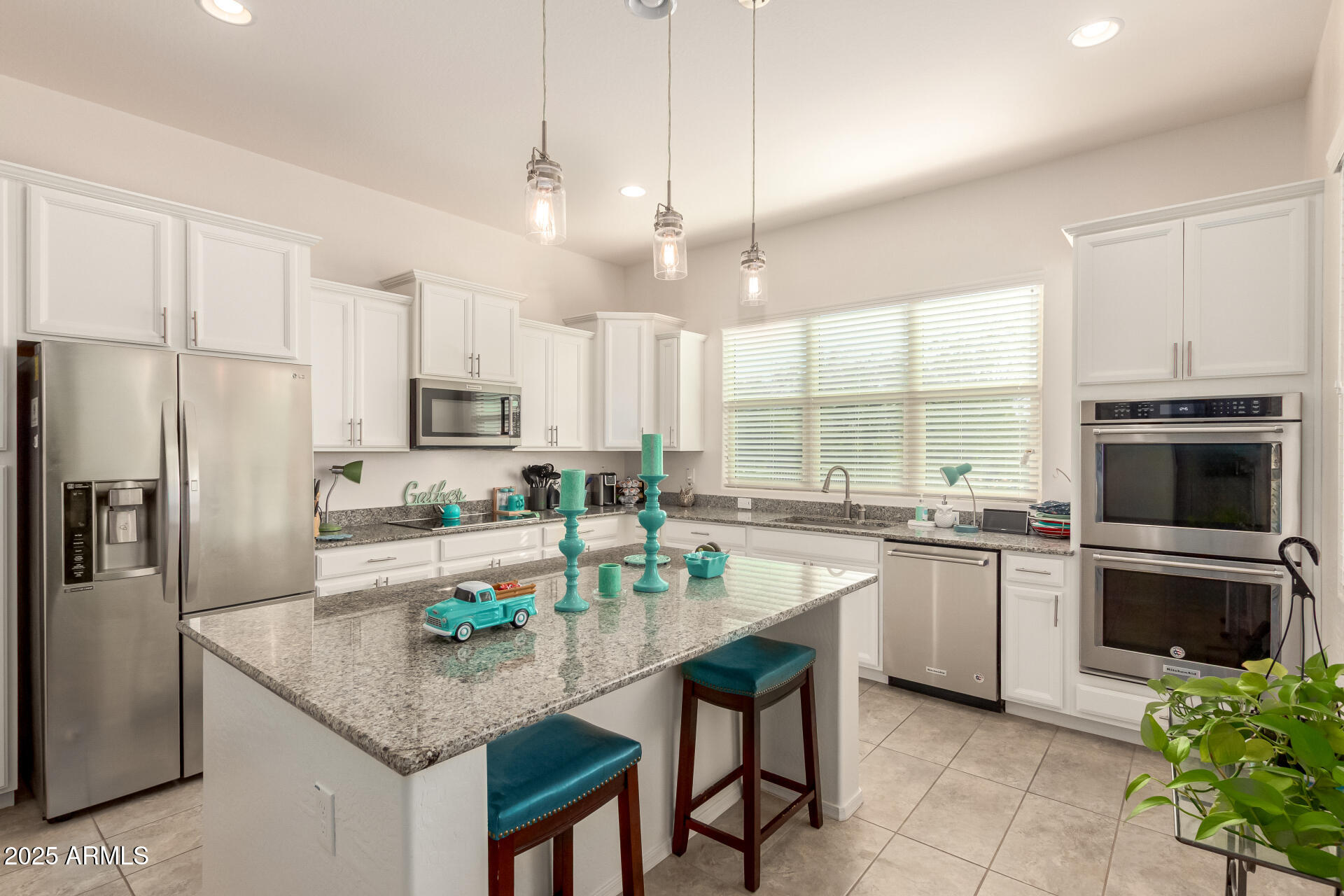 42851 West Mallard Road Maricopa, AZ 85138 - Photo 15 of 45 a kitchen with kitchen island granite countertop a stove a sink a oven a counter space and dining table chairs