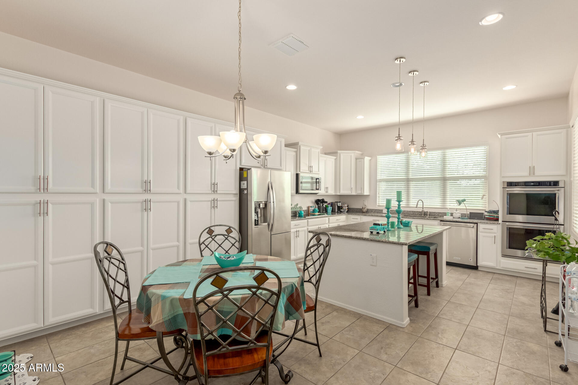 42851 West Mallard Road Maricopa, AZ 85138 - Photo 17 of 45 a kitchen with stainless steel appliances kitchen island granite countertop a table chairs and a refrigerator