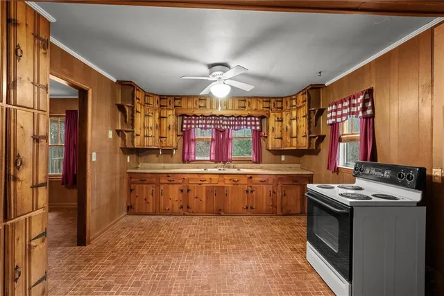 a kitchen with granite countertop a sink stove and refrigerator