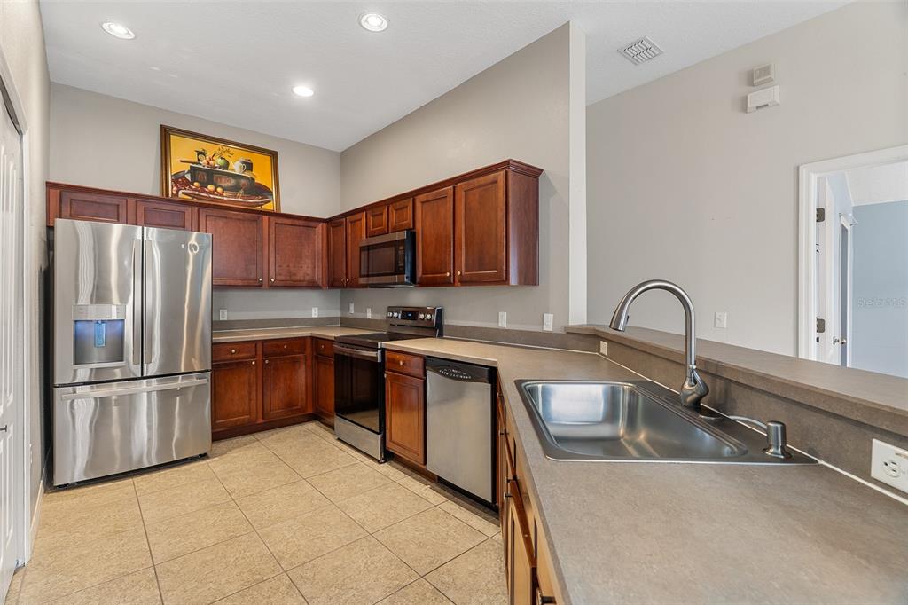 3555 Clay Brick Road, Unit 46A Harmony, FL 34773 - Photo 10 of 54 a kitchen with stainless steel appliances granite countertop a refrigerator sink and cabinets