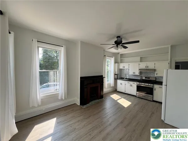 a kitchen with stainless steel appliances kitchen island granite countertop a stove a refrigerator a sink a oven with a dining table and chairs