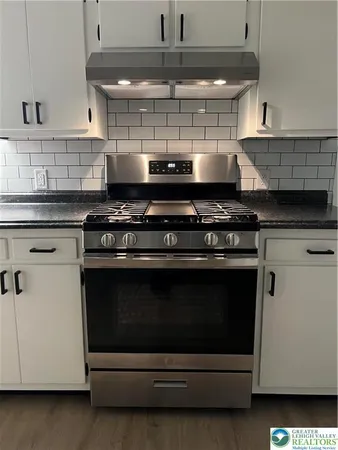 a stove top oven sitting inside of a kitchen