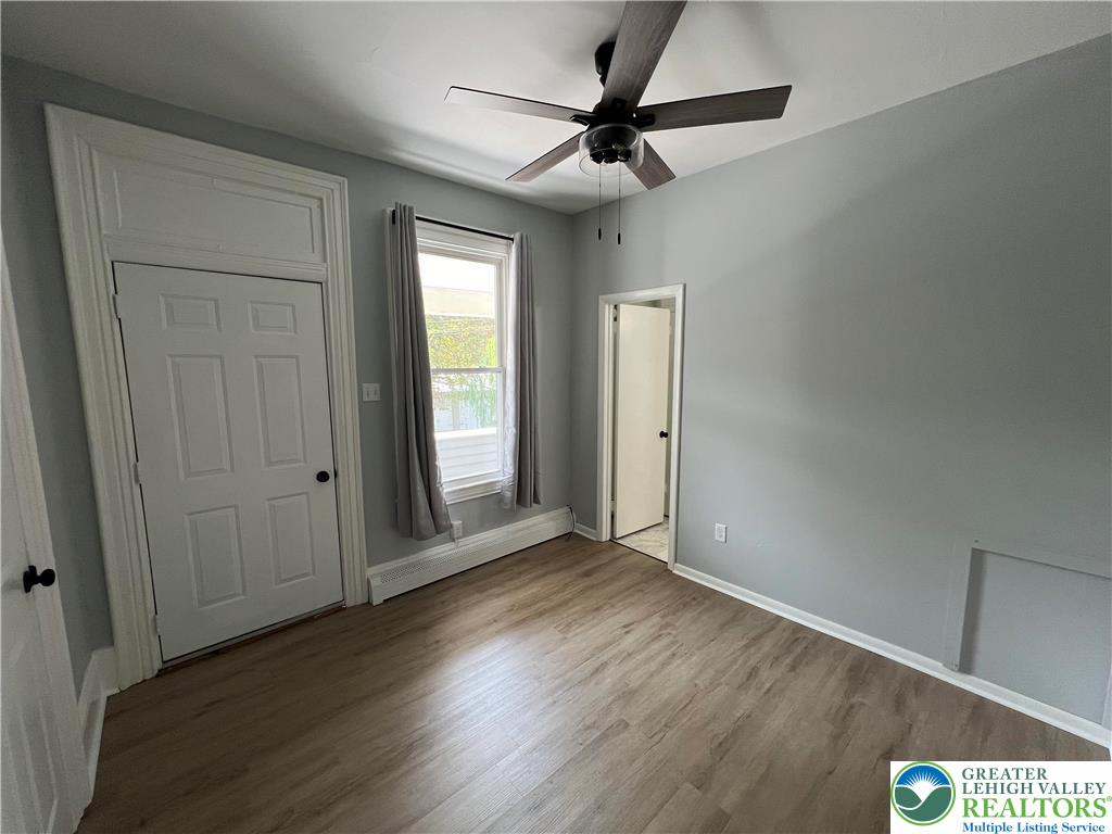 101 Center Street, Unit 1A Jim Thorpe, PA 18229 - Photo 9 of 18 an empty room with wooden floor fan and windows