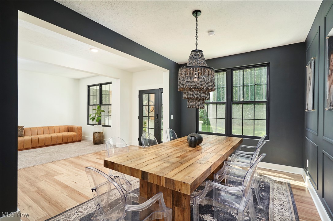 7754 Bainbridge Road Chagrin Falls, OH 44023 - Photo 8 of 35 Dining area with light wood finished floors, a chandelier, and a textured ceiling