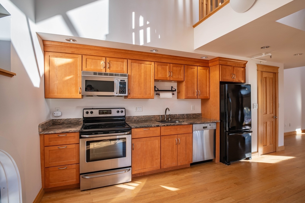43 Center Street, Unit K Northampton, MA 01060 - Photo 2 of 18 a kitchen with stainless steel appliances a stove sink and refrigerator