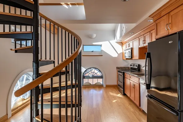 a dining room with wooden floor and stairs