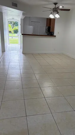 a view of a kitchen with an empty space and a window