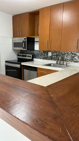 a kitchen with stainless steel appliances wooden cabinets and a counter top space