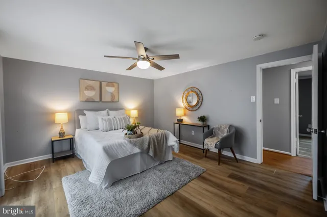 a bathroom with a granite countertop toilet a sink a mirror and vanity
