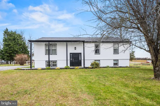 a view of a house with a big yard and large trees