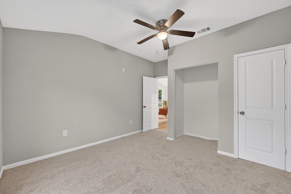 538 Pemberton Hill Road Dallas, TX 75217 - Photo 11 of 31 Carpeted interior room featuring light gray walls, white trim, a vaulted ceiling, a ceiling fan with integrated lighting, and a recessed alcove