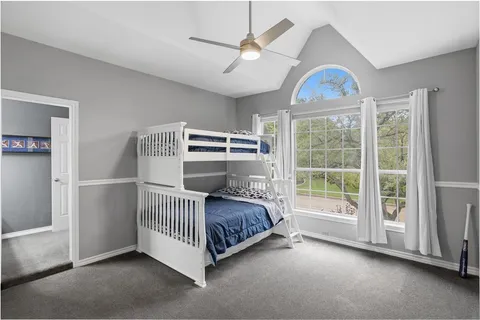 a spacious bedroom with a bed and a chandelier