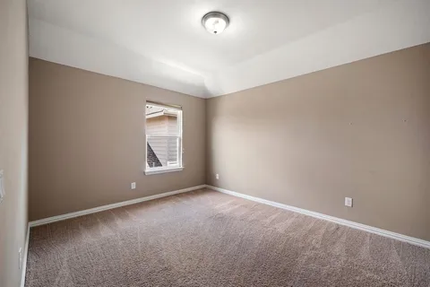 a view of an empty room with window and closet area