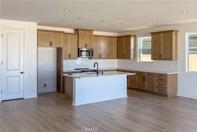 a large kitchen with stainless steel appliances granite countertop a refrigerator and a sink